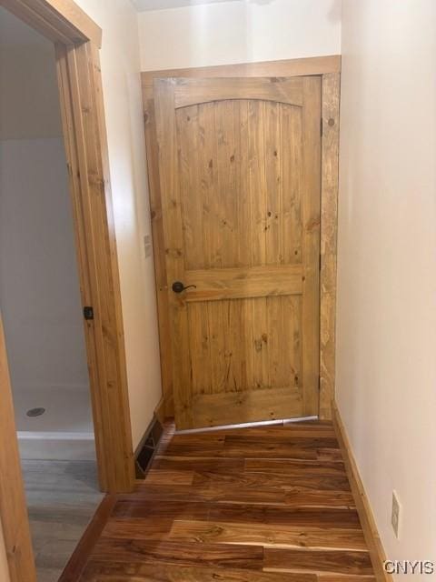 doorway to outside featuring wood finished floors and baseboards