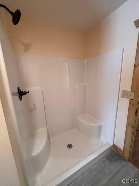 bathroom featuring wood finished floors and walk in shower