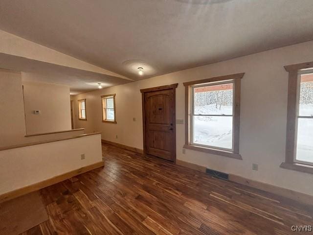 interior space featuring a wealth of natural light, baseboards, and dark wood-type flooring