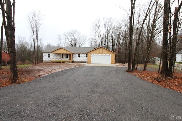 view of front of property featuring a garage, covered porch, and driveway