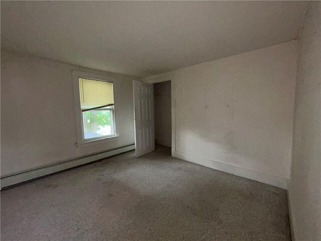 spare room featuring a textured ceiling and a baseboard heating unit