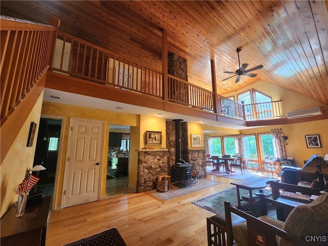 living room with wooden ceiling, a wood stove, high vaulted ceiling, light hardwood / wood-style flooring, and ceiling fan