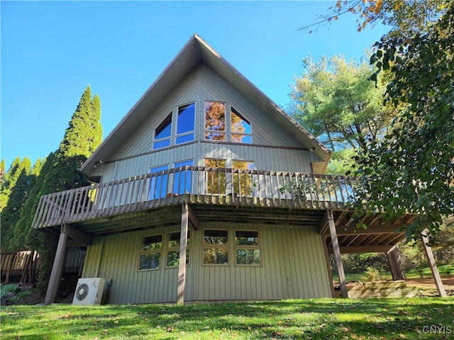 rear view of house with a lawn, ac unit, and a deck