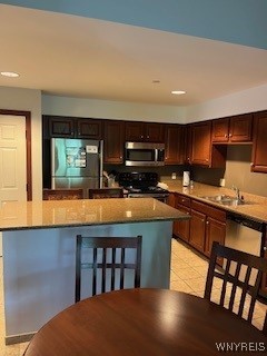 kitchen featuring light tile patterned floors, appliances with stainless steel finishes, sink, and light stone counters