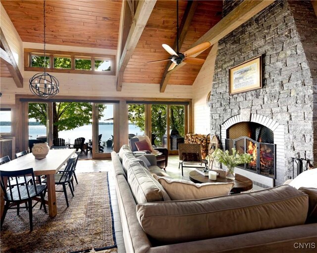 living room with high vaulted ceiling, wooden ceiling, a water view, a fireplace, and beamed ceiling