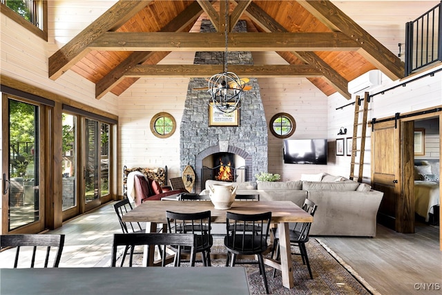 dining room featuring wooden ceiling, a fireplace, a barn door, and wood-type flooring