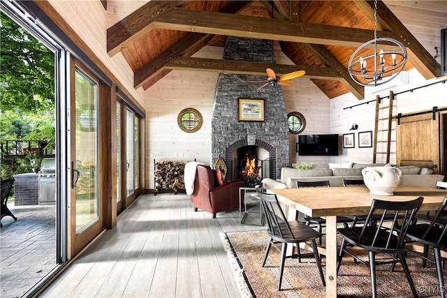 dining room featuring light hardwood / wood-style flooring, a barn door, plenty of natural light, and wood ceiling