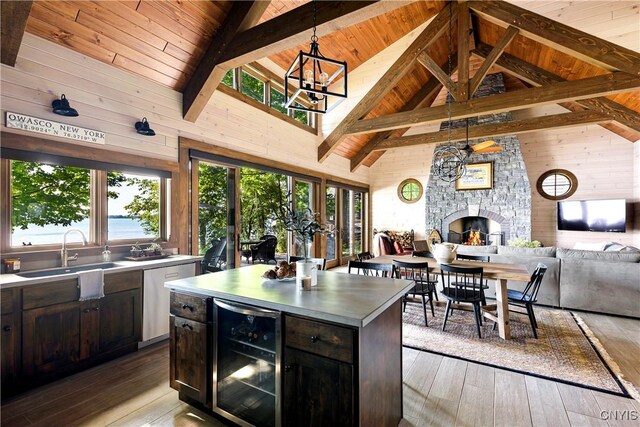 kitchen with wooden ceiling, a stone fireplace, a center island, wine cooler, and wood-type flooring