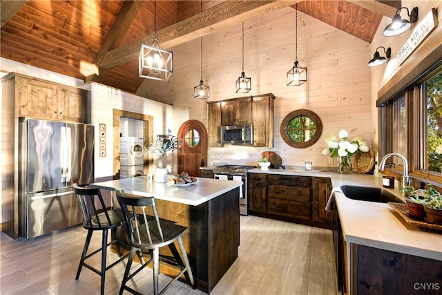 kitchen featuring sink, stainless steel appliances, light hardwood / wood-style flooring, and wooden ceiling