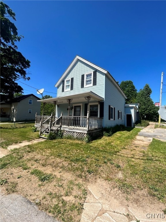 view of front facade featuring covered porch and a front yard