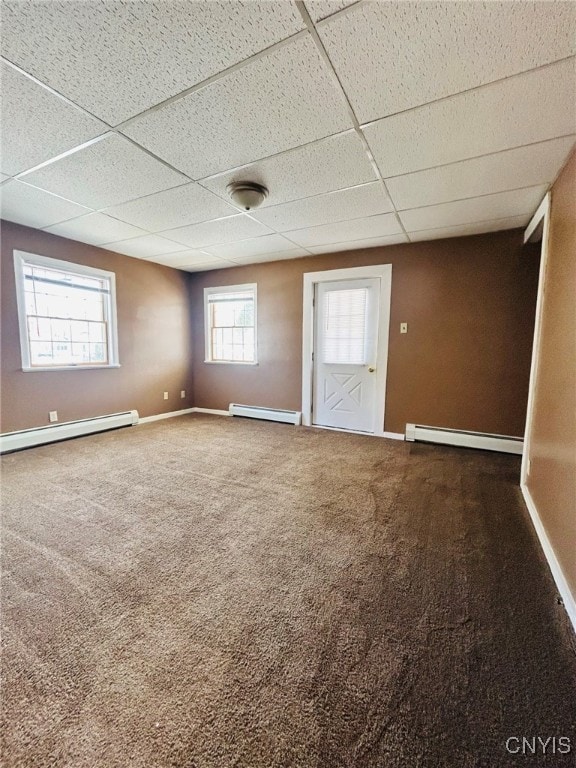 unfurnished room with a drop ceiling, carpet floors, and a baseboard radiator