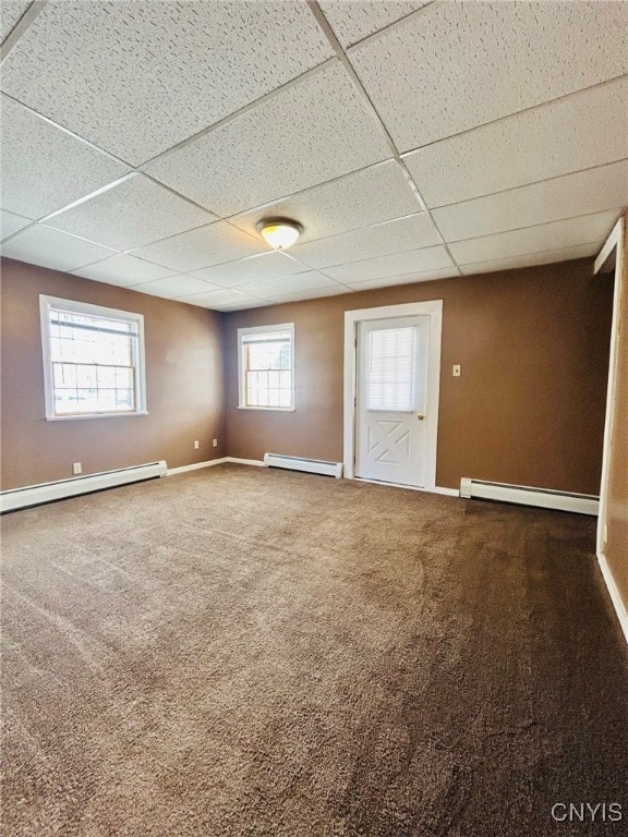 unfurnished room featuring a paneled ceiling, a baseboard heating unit, and carpet floors