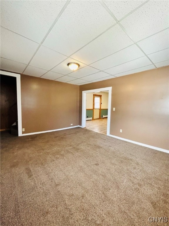 spare room with a drop ceiling and carpet flooring