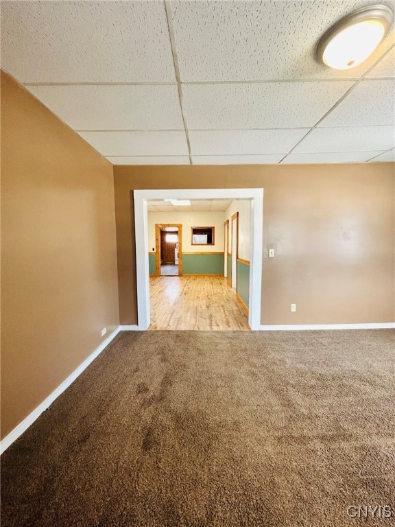 spare room featuring carpet and a drop ceiling