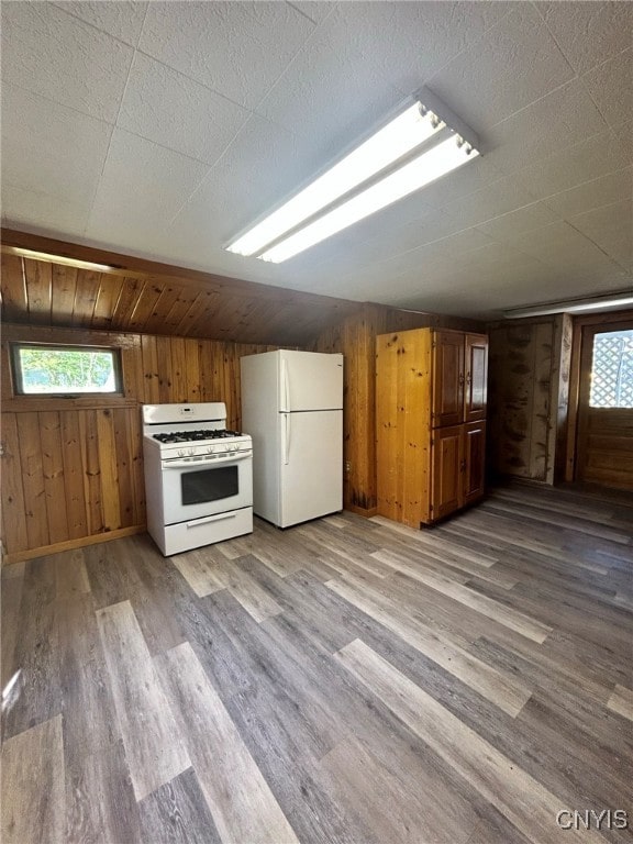 interior space featuring wooden walls, hardwood / wood-style floors, and lofted ceiling