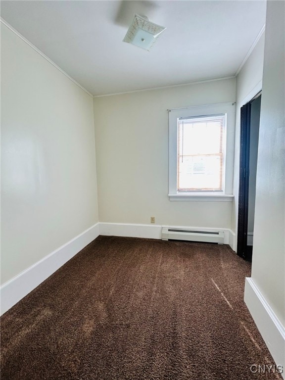 spare room with ornamental molding, baseboard heating, and carpet floors