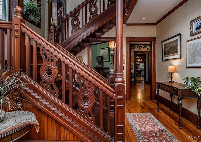 staircase featuring ornamental molding and hardwood / wood-style flooring