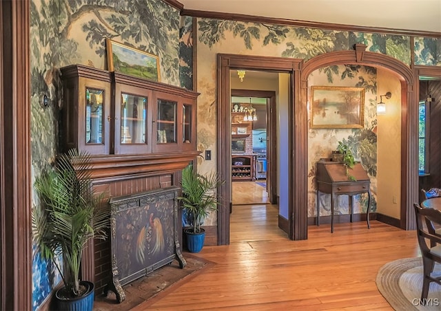 foyer entrance with ornamental molding and wood-type flooring