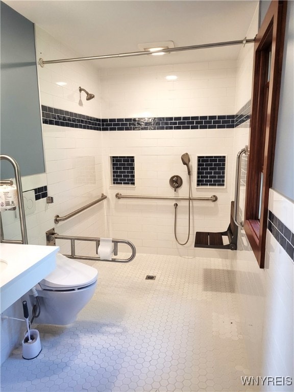 bathroom featuring a tile shower, tile walls, and toilet