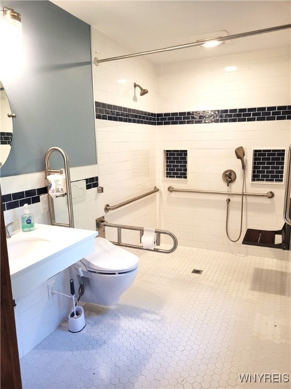 bathroom with tile walls, tiled shower, vanity, and toilet