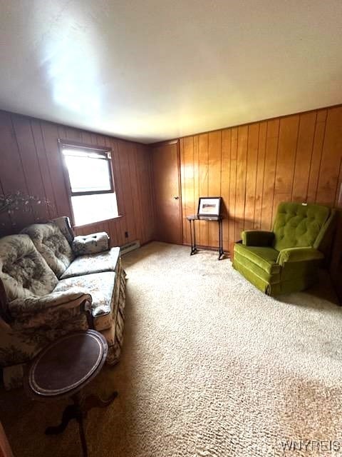 living room featuring light colored carpet, wooden walls, and baseboard heating