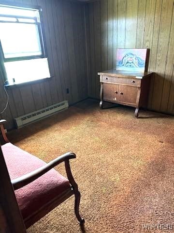 bedroom featuring light carpet, a baseboard radiator, and wood walls