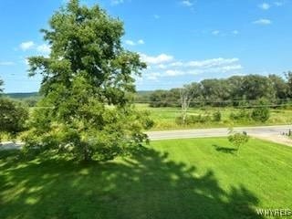 view of home's community with a rural view and a yard