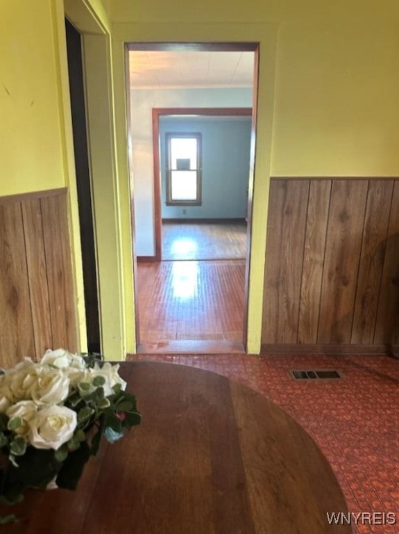 corridor featuring wooden walls and hardwood / wood-style flooring