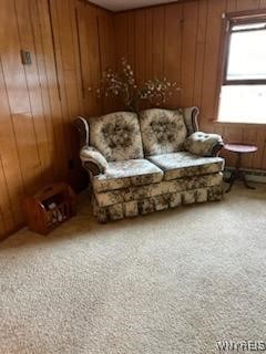 sitting room featuring wood walls and carpet flooring