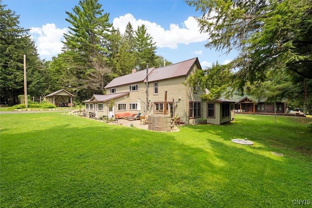 back of property with an outdoor hangout area, a patio area, and a lawn