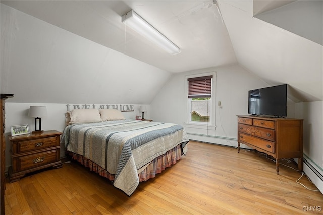 bedroom featuring baseboard heating, light hardwood / wood-style flooring, and vaulted ceiling