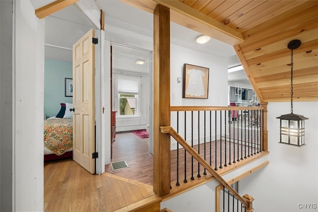 corridor with vaulted ceiling, wooden ceiling, and hardwood / wood-style flooring