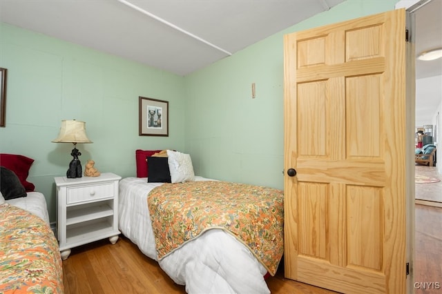 bedroom featuring hardwood / wood-style floors and vaulted ceiling