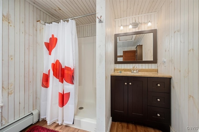 bathroom with a baseboard radiator, wood walls, hardwood / wood-style flooring, and walk in shower