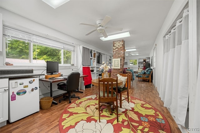 dining space featuring decorative columns, ceiling fan, and light hardwood / wood-style flooring