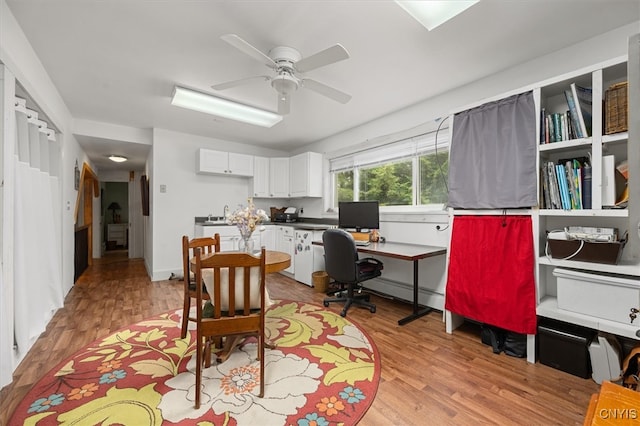 home office with ceiling fan and light hardwood / wood-style flooring