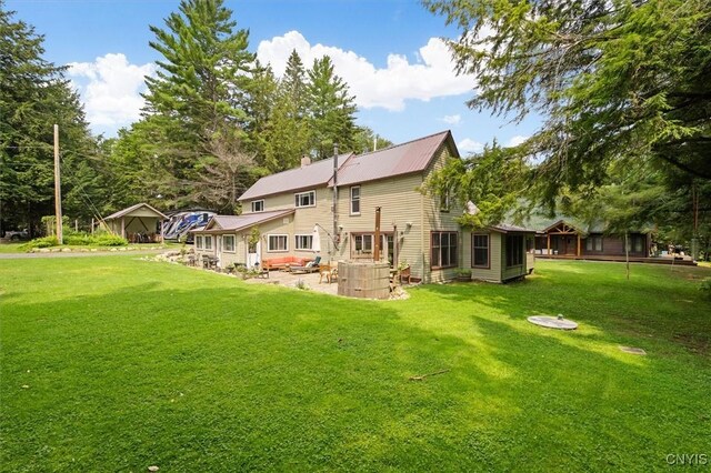 back of house with a yard, an outdoor hangout area, and a patio area