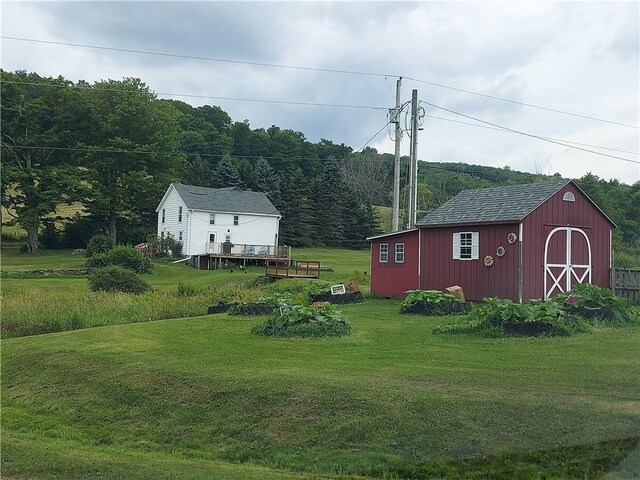 view of yard featuring a deck and an outdoor structure