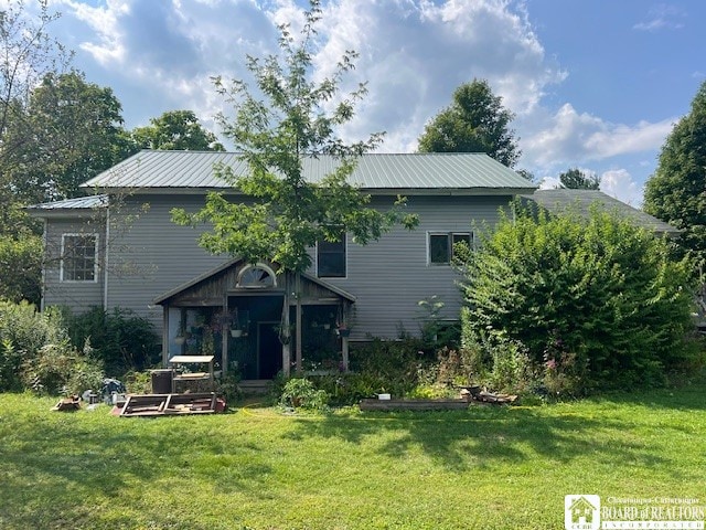 rear view of property with a yard