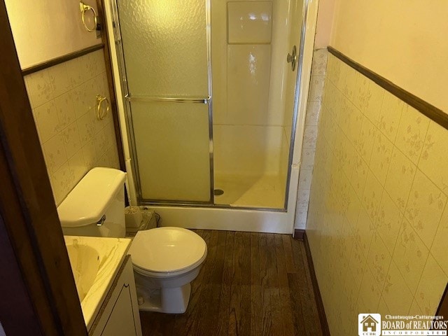 bathroom featuring tile walls, toilet, vanity, and hardwood / wood-style flooring