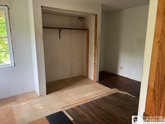 unfurnished bedroom featuring hardwood / wood-style flooring and a closet