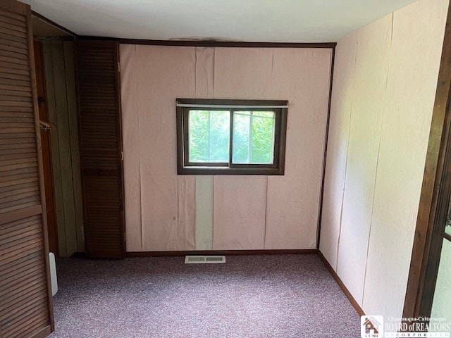 unfurnished bedroom with light colored carpet and a closet