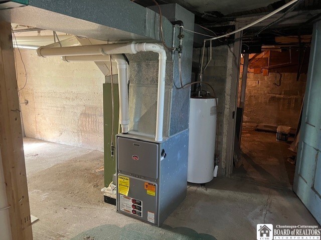 utility room featuring heating unit and gas water heater