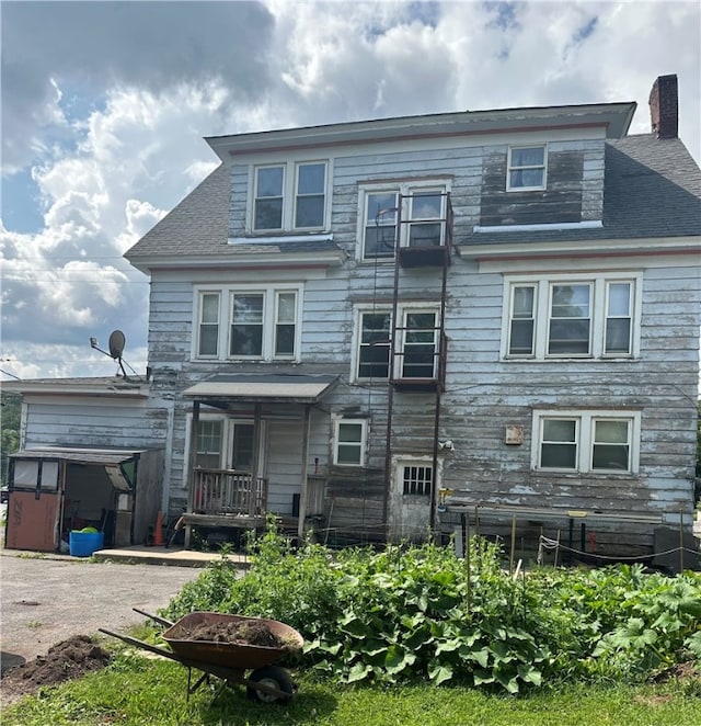 back of house featuring a storage unit