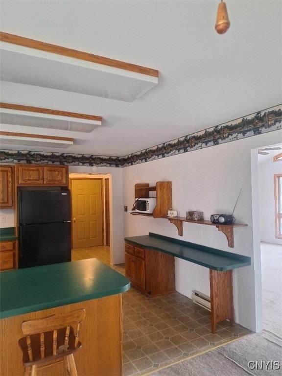 kitchen featuring black refrigerator and a baseboard radiator