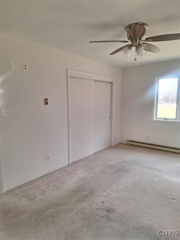 unfurnished bedroom featuring ceiling fan, a closet, light colored carpet, and a baseboard radiator