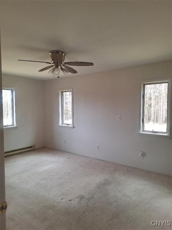 carpeted empty room featuring baseboard heating and ceiling fan