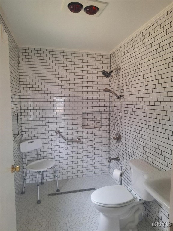 bathroom featuring toilet, a tile shower, and crown molding