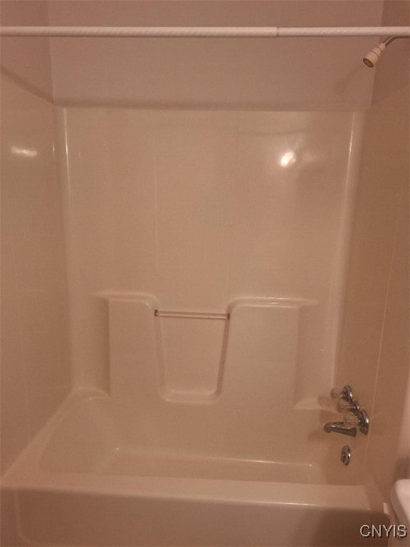 bathroom with washtub / shower combination and toilet