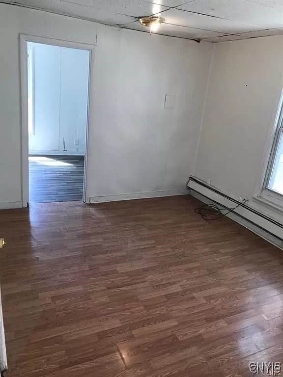 spare room with hardwood / wood-style flooring and a baseboard radiator